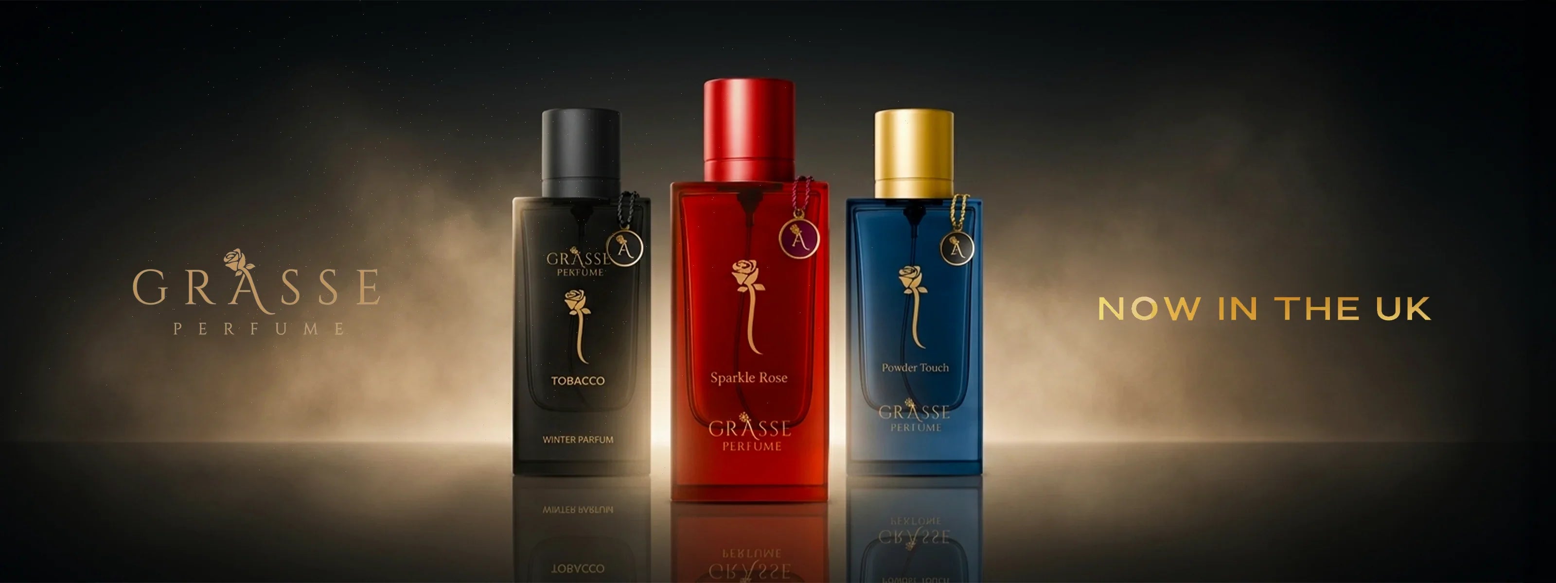 Three Grasse perfume bottles in black, red, and blue with gold accents, luxury fragrance display.