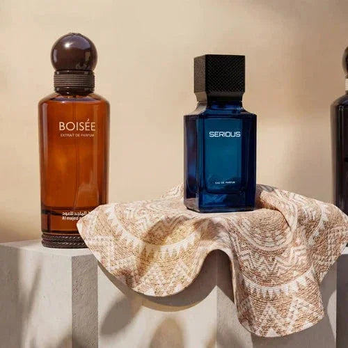 Luxury Middle Eastern perfumes Boisée and Serious on patterned fabric, showcasing exotic fragrance bottles